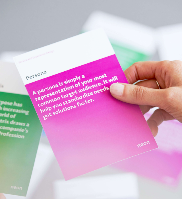 a female hand is holding one of "neons method cards", that explains how to do Personas